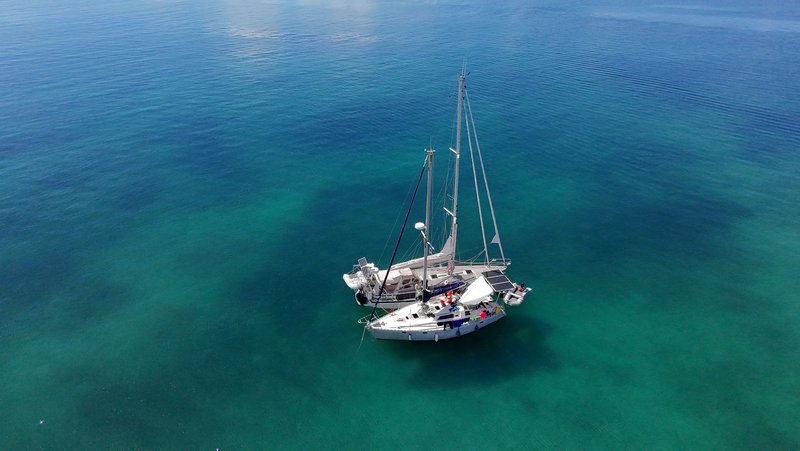 Aerial view of Tinarasia at anchor alone in clear turquoise water